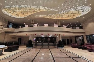 Un hall amplio con techo curvo, varios niveles y una recepción central.