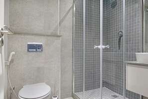 A modern bathroom with a toilet, a shower with a glass door, and a sink. - 601 at Two six two Florida Road (Durban)