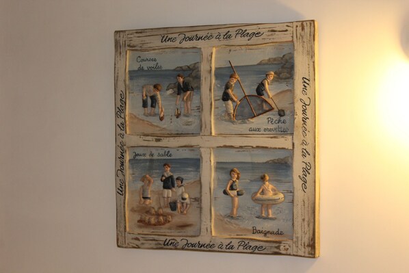 A wall-mounted artwork depicting children engaging in various seaside activities. - Family home with a fenced-in yard in a wooded area, 900 meters from the beach (Longeville-sur-Mer)