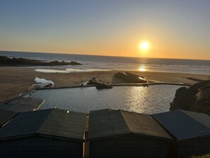 A beach with a sunset, rocky outcrops, and a wooden structure with a roof. - Bescot House, Bramble Hill, Bude, 4 bed det House (Bude)