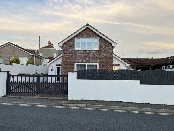 A two-story house with a brick facade, a white front wall, and a black gate. - Bescot House, Bramble Hill, Bude, 4 bed det House (Bude)