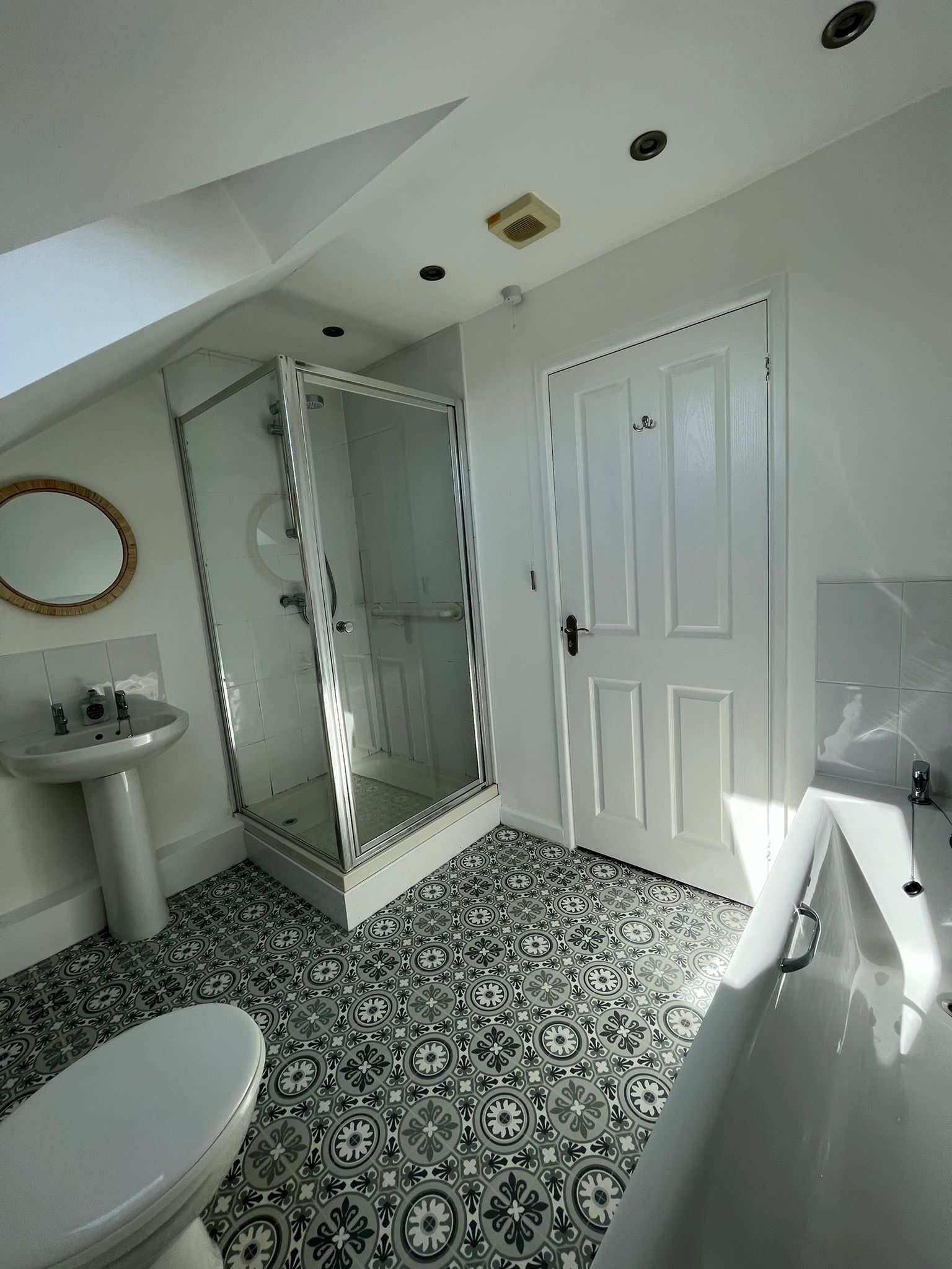 A bathroom with a shower, toilet, sink, and bathtub.