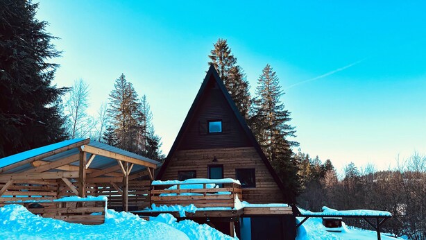 A wooden cabin with a steeply pitched roof, surrounded by snow-covered ground and trees. - Chalet du Fayard in Belfahy, private Jacuzzi and view of the Vosges mountains (Belfahy)