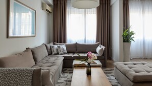 Un salon moderne avec un canapé d’angle, une table basse et une plante en pot.