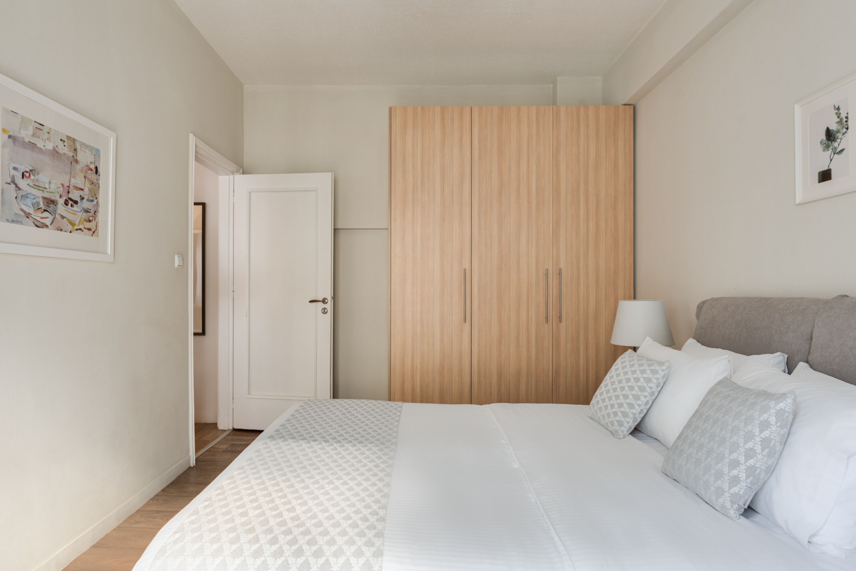 A bedroom with a bed, a wardrobe, and a nightstand.