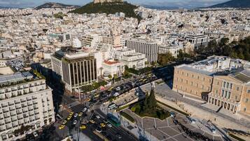 A cityscape with a prominent hill in the background, featuring a mix of modern and historical architecture.