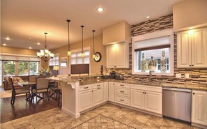 Enjoy cooking in this well-lit kitchen with a large island, sink, and adjacent dining area.