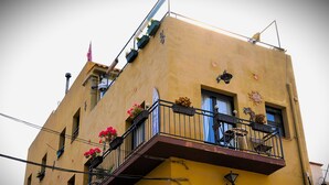 Un edificio de varios pisos con balcones, algunos con jardineras.