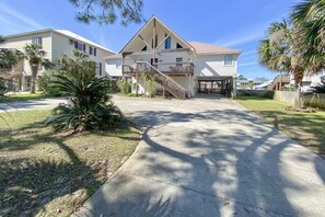 Une maison à deux étages avec un balcon, une véranda et une allée.
