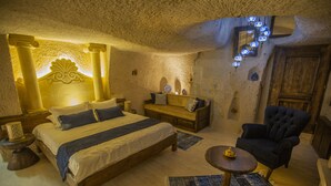 Une pièce confortable avec un lit, un canapé, un fauteuil et une petite table.