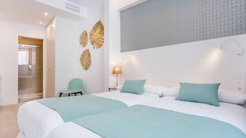 A hotel room with two beds, a green chair, and a decorative wall panel.