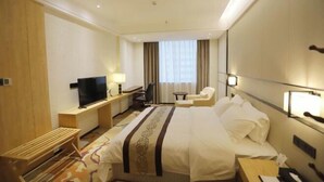 Une chambre d’hôtel équip ée d’un lit, d’une télévision, d’un bureau, d’une chaise et d’une fenêtre avec des rideaux.