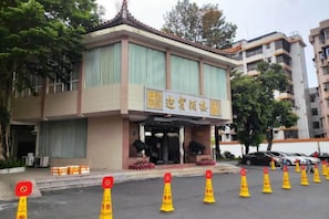 A building with a traditional architectural style, featuring a prominent entrance with a tiled roof and a signboard. - Nanxiong Guest House (Nanxiong)