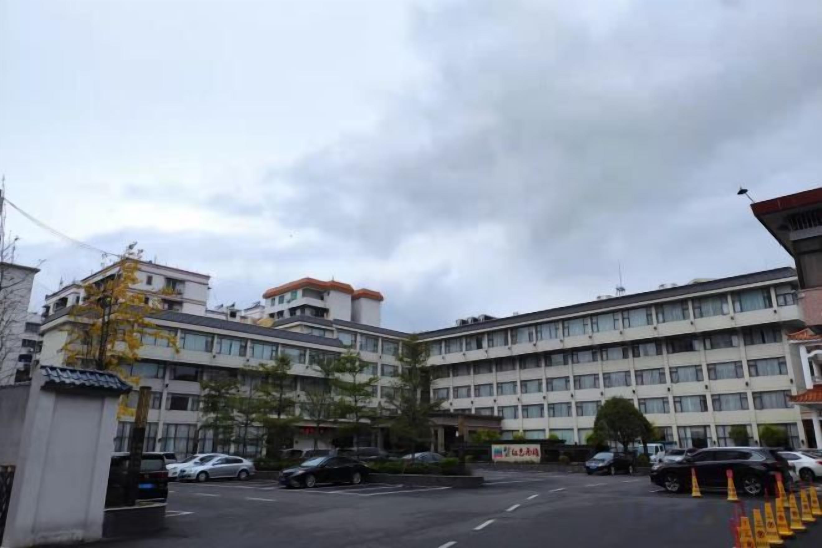 A multi-story building with a parking lot in front.