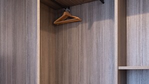 En rummelig garderobe med træhylder og bøjlestang.