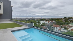 A rooftop pool with a city view, surrounded by greenery and residential buildings. - 707 at Two six two Florida Road (Durban)