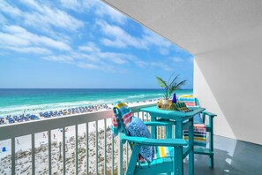 Ein Balkon mit Blick auf Strand und Meer.