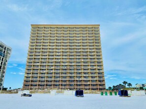Ein Hochhaus-Hotel mit mehreren Balkonen und Blick auf den Strand.