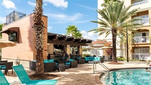 Ein Poolbereich mit Liegestühlen, einer Bar und einem Pool.