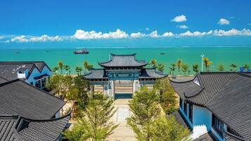 A traditional Chinese gate with a view of the sea and boats.