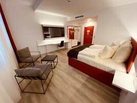 Una habitación de hotel moderna con una cama grande, un escritorio y una silla.
