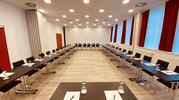 Uma sala de conferência com uma mesa comprida, cadeiras e placas de identificação.