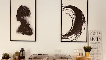 Two framed abstract paintings, a vintage-style metal container, and a decorative sign with text.