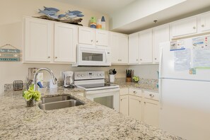 Enjoy cooking in this well-equipped kitchen with a gas stove, microwave, and refrigerator.