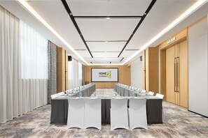 A conference room with a long table, white chairs, and a screen displaying 'HOME 2' branding. - Home2 Suites By Hilton Shenzhen Dalang (Shenzhen)