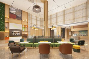 A spacious indoor area with seating arrangements, a large wall with a mural, and a section labeled 'FREE to be you'.