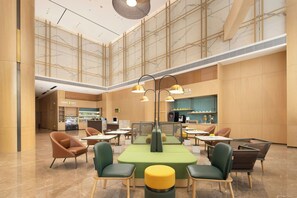 A spacious indoor area with seating arrangements, a counter with a menu, and a vending machine.