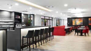Zona de bar moderna con mostrador, taburetes y asientos.
