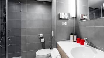Un baño moderno con ducha, inodoro y lavamanos.