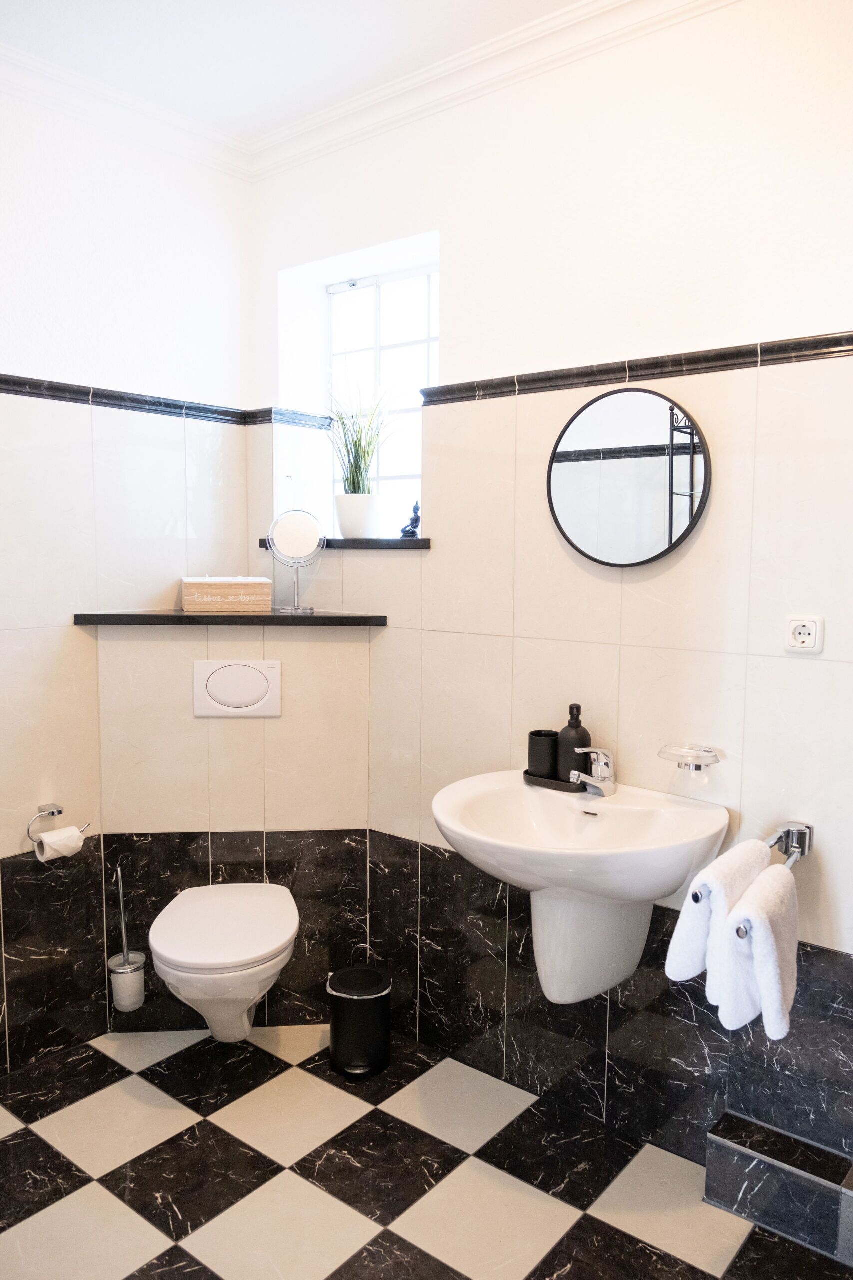 A bathroom with a toilet, sink, and mirror.