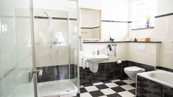 Ein modernes Badezimmer mit einer Duschkabine, einem Waschbecken, einer Toilette und einer Badewanne.