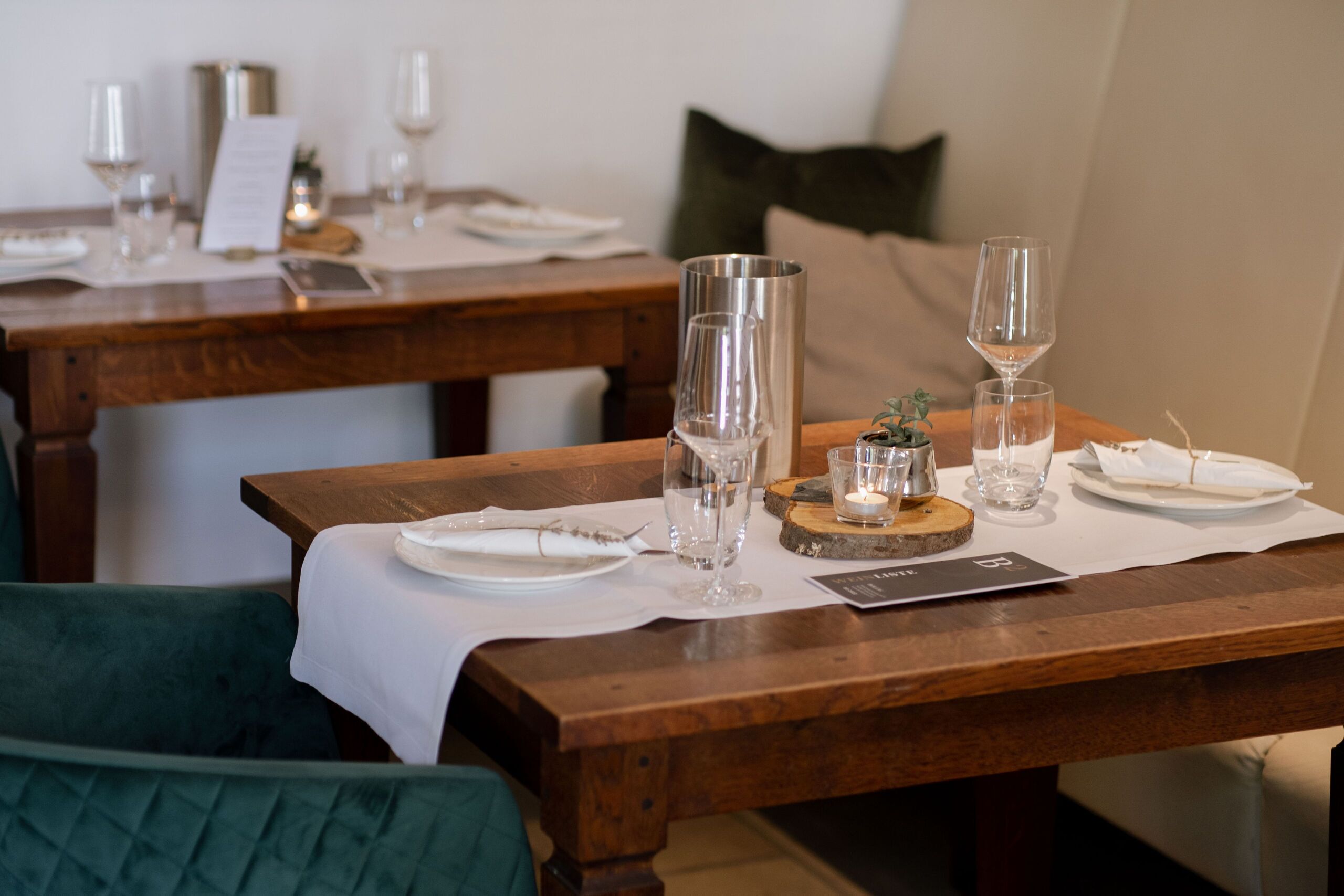 Et spisebord dækket med tallerkener, glas og en menu, der signalerer en restaurant.