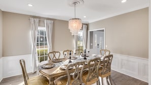 A dining room with a large wooden table, ornate chairs, and a chandelier. - Royal Meadows (Jackson)