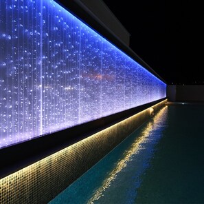 Una piscina al aire libre, sillones reclinables de piscina