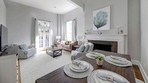 Un salon moderne avec une cheminée, une table à manger dressée et un canapé.