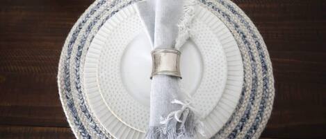 A round table with a white plate and a napkin holder.