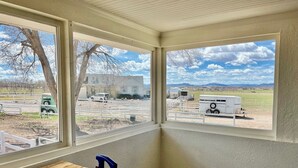 A room with a large window overlooking a parking area with RVs and a white building. - The Spacious, Vintage House on the Ranch
 (Enoch)