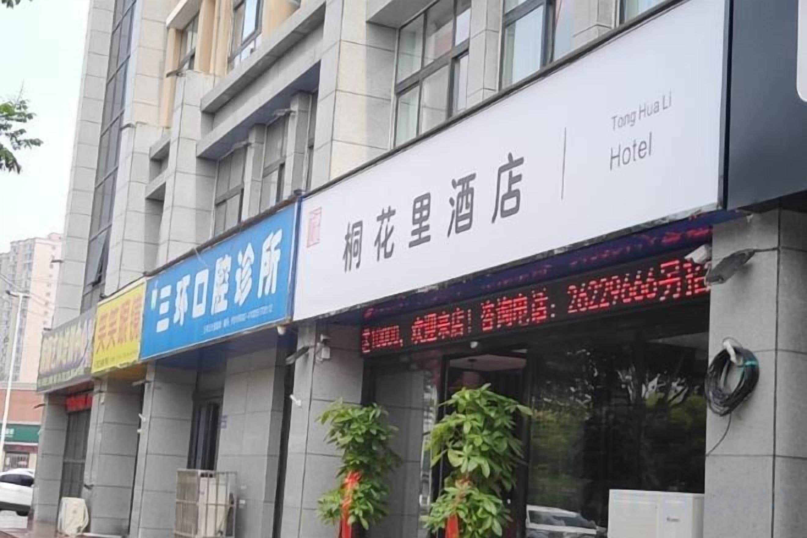 A hotel with a signboard displaying the name and a digital display with information.