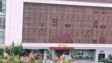 A building with a modern facade, large windows, and a prominent red sign.