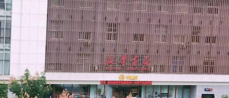 A building with a modern facade, large windows, and a prominent red sign.