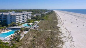 A beachfront hotel with a swimming pool, beach access, and a view of the ocean.