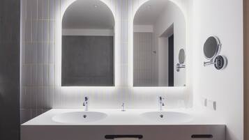 Un baño moderno con dos lavamanos, un espejo grande y un mueble de tocador empotrado.