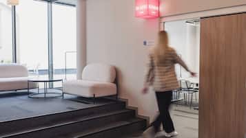 Un interior moderno con una escalera, una zona de estar y una sala de conferencias.