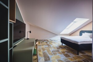 Un dormitorio con cama, escritorio y televisión.
