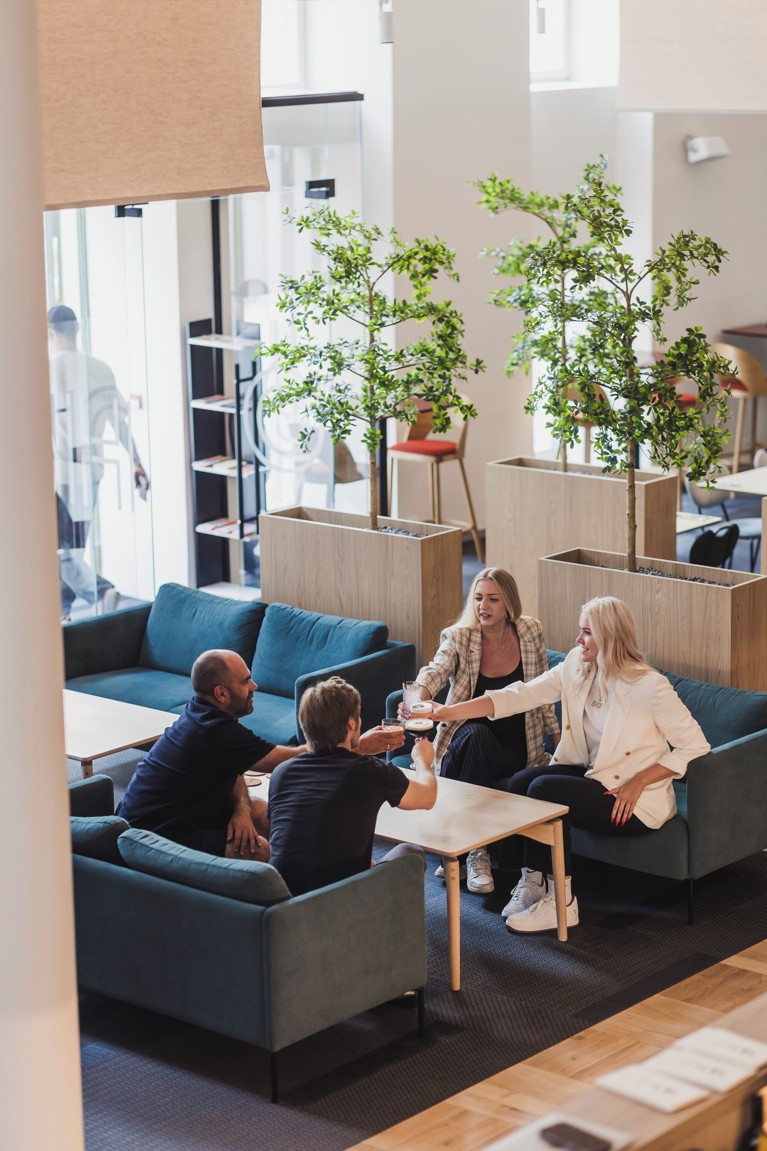Un espacio lounge moderno con arreglos de asientos y plantas de interior.