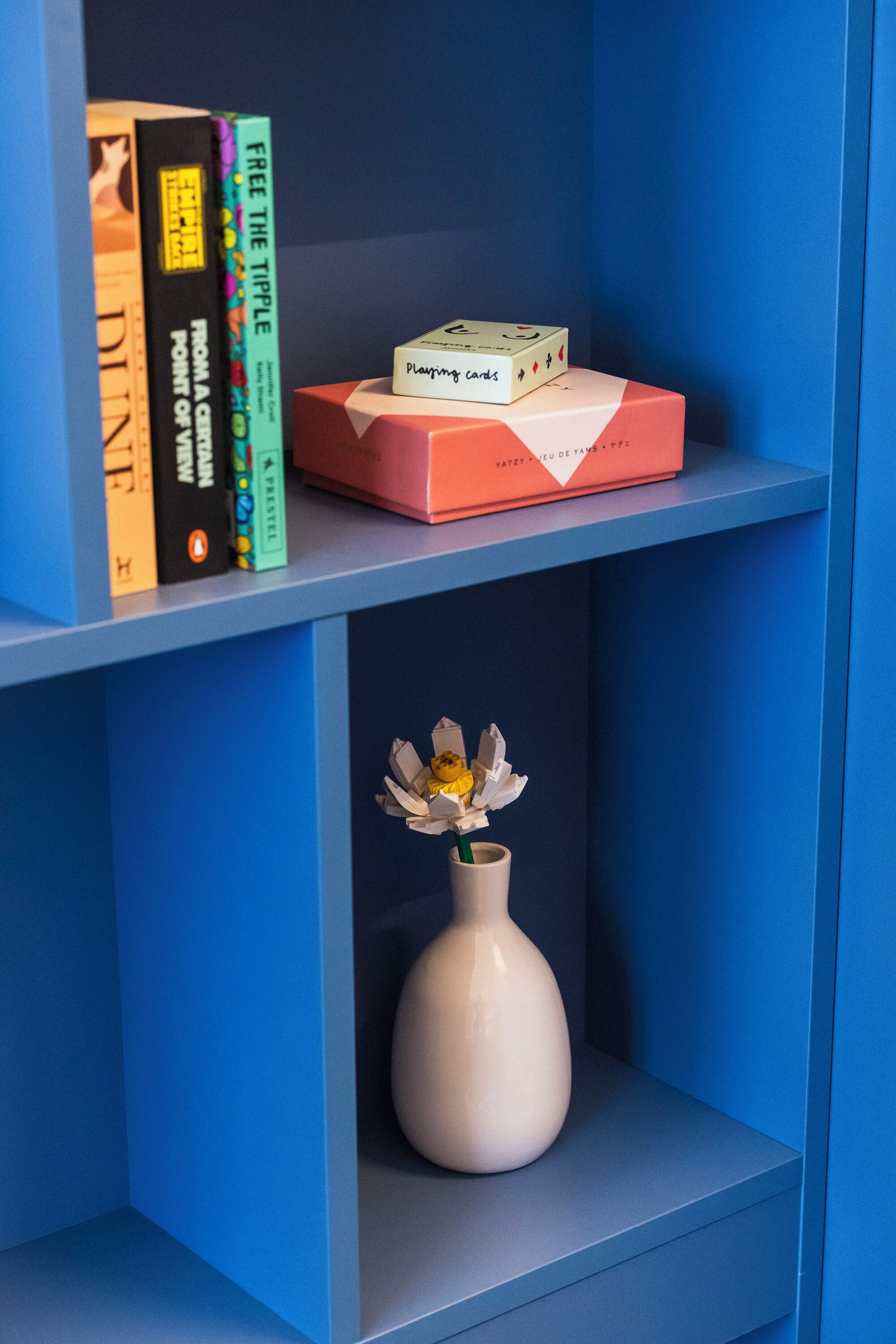 Una estantería con libros y una caja de cartas.